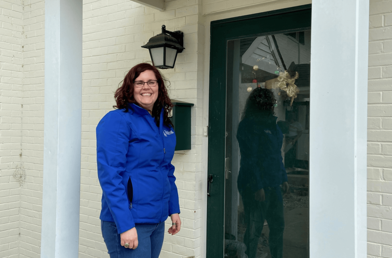 a person in a blue jacket standing in front of a glass door