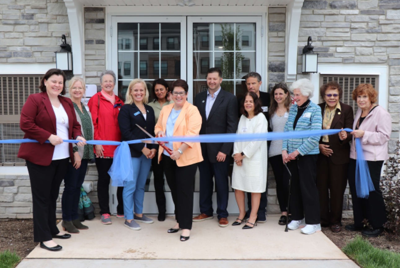 a group of people cutting a ribbon