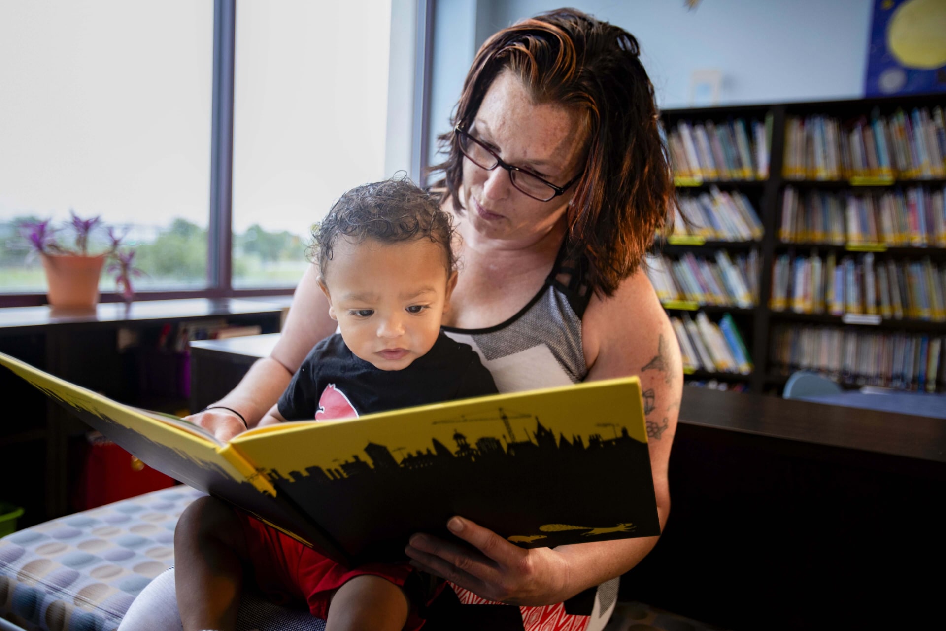 a person reading a book to a child