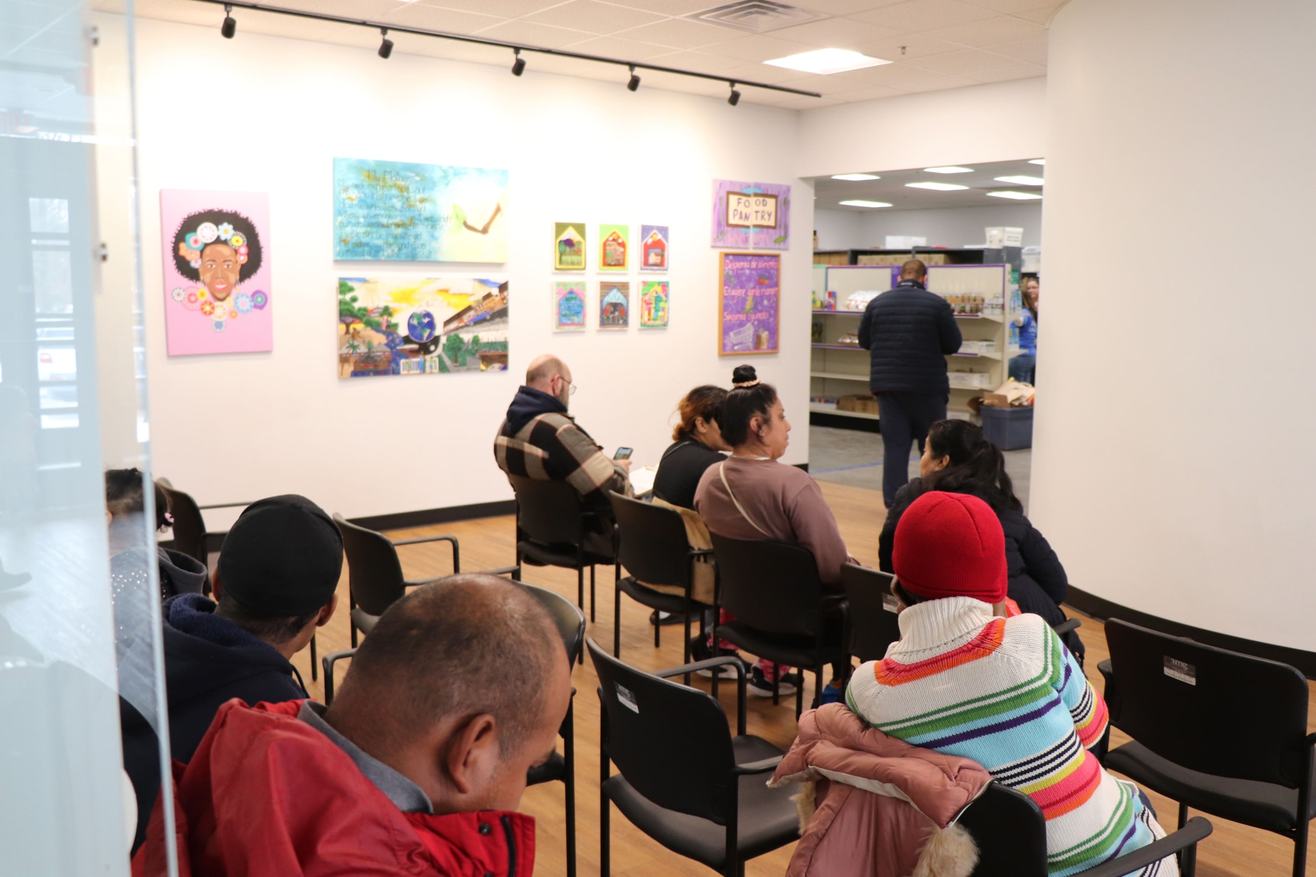 a group of people sitting in chairs in a room with art on the wall