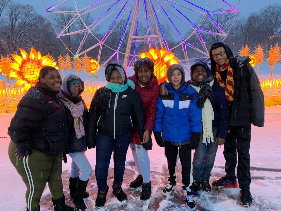 a group of people posing for a photo in front of a ferris wheel